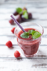 Fresh smoothie in a glass. Bright wooden background. Close up.