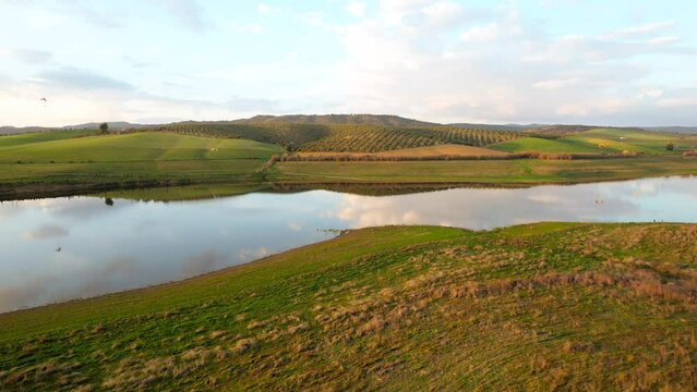 lago sobrevolado por parapentes fantastico