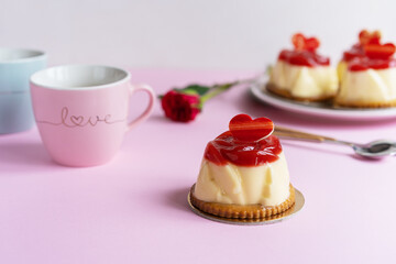 Bavarian cream pastry with strawberry jelly, two cups and rose