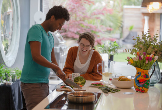 Happy couple cooking in kitchen