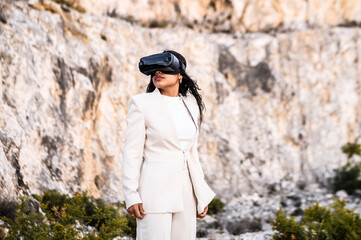 Una elegante mujer vestida con un traje blanco usando unas gafas de realidad virtual