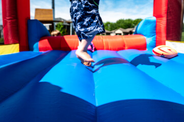 Selective focus on foreword edge of a bouncy house with blurred children playing in the background