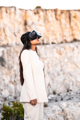 Una elegante mujer vestida con un traje blanco usando unas gafas de realidad virtual