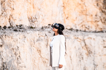Una elegante mujer vestida con un traje blanco usando unas gafas de realidad virtual