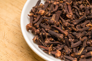 close up of cloves isolated on white bowl (Syzygium aromaticum)