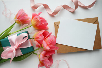 greeting card layout. a bouquet of pink tulips and a gift box with a pink bow 