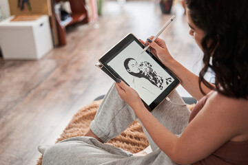 Female illustrator holding tablet and preparing new black and white picture while working
