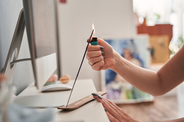 European girl using lighter and burning aroma stick with fire