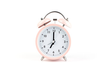 Pink vintage alarm clock on white isolated background.