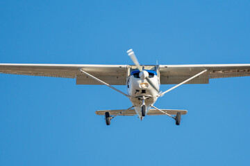 Small plane flying with sunset light in a clear sky before landing on Sabadell Airport