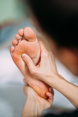 Therapeutin behandelt Fuss einer Frau in Reflexzonen