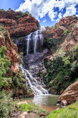 Fototapeta premium View of a waterfall and river in a mountainous area in Walter Sisulu National botanical gardens, Johannesburg, South Africa