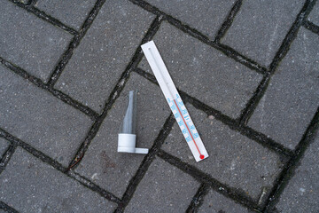 Fototapeta premium broken mercury thermometer lying on the pavement