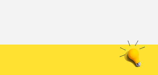 Yellow light bulb - flat lay from above - inspiration, creativity, energy, electricity themes