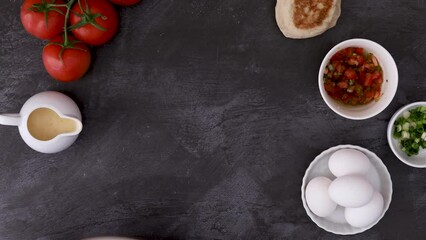 Serving a Plate of Mexican Eggs Benedict with Salsa