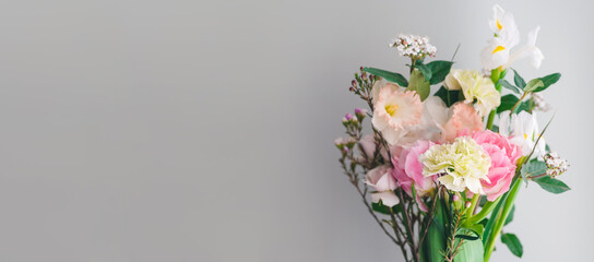 beautiful bouquet of carnations, daffodils, spray roses and white irises on a gray background, copy space