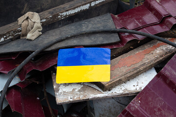 Bright Ukrainian flag on a ruins of a house in Ukraine. 