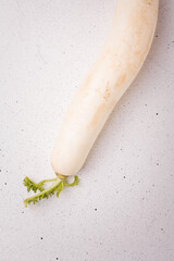 Daikon, east long radish on white background. Fresh organic vegan farm vegetables, seasonal harvest, healthy food.