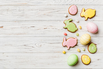 holiday preparation Multi colors Easter eggs with cookies on colored background . Pastel color Easter eggs. holiday concept with copy space