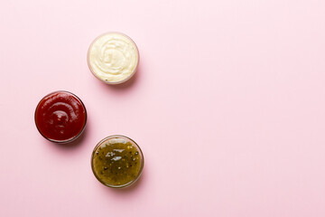 Different types of sauces in bowls on a colored Board . Top view. various sauces copy space