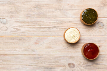 Different types of sauces in bowls on a colored Board . Top view. various sauces copy space