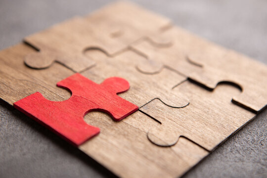 Creative idea and solve the problem concept. Teamwork success strategy - wooden puzzle on the grey background