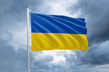Ukrainian flag on a flagpole waving in the wind on a cloudy sky background. Flag of Ukraine
