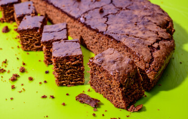 Sweet chocolate cake isolated on green background. Tasty creamy cake.