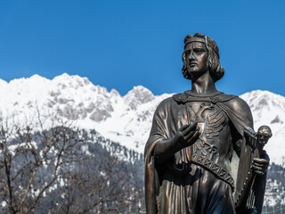 Denkmal Walther von der Vogelweide vor schneebedeckten Bergen in Innsbruck