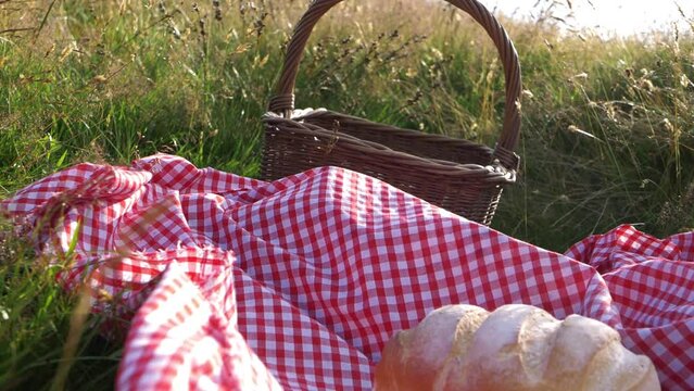 Vintage picnic basket and red gingham blanket with fresh loaf of bread 