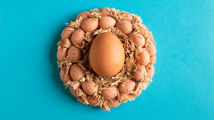 Obraz na płótnie Canvas A pile of brown eggs in a nest. Minimal Easter concept. Copy space. Flat lay.
