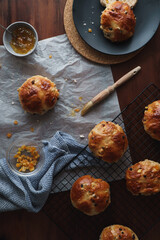 Flat lay food image of traditional Easter treats. Freshly baked hot cross buns. Baking equipment and ingredients included in frame. Copy space available