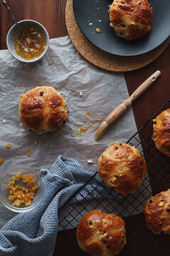 Flat lay food image of traditional Easter treats. Freshly baked hot cross buns. Baking equipment and ingredients included in frame. Copy space available