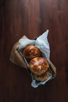 
Close Up Shot From Above Down Onto Hot Cross Buns In A Baking Tray. Easter Bakes Set Against A Dark Background Lots Of Copy Space Available