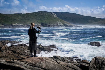 Young and beautiful woman taking photos with the mobile on the coast of Galicia