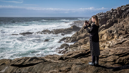 Young and beautiful woman taking photos with the mobile on the coast of Galicia