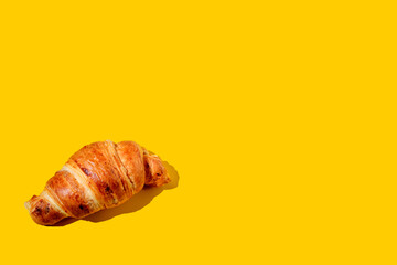 Fresh butter Croissant on a yellow background. Flat lay style.