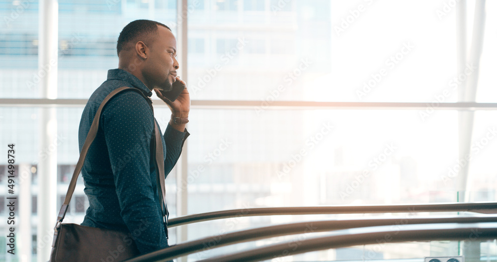 Poster on call and on the move. cropped shot of a handsome young businessman taking a phonecall while going