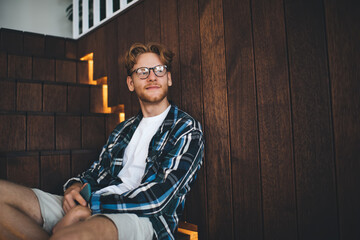 Young guy sitting on stairs and resting in office