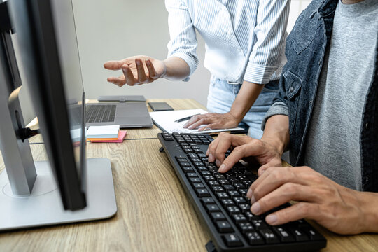 Two professional programmer cooperating and working on web site project in a software developing on desktop computer at company, codes and typing data code, Programming with HTML, PHP and javascript