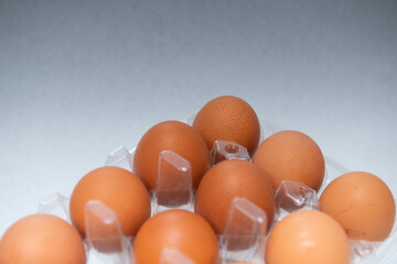 tray with 15 brown eggs on a white-grey gradient background