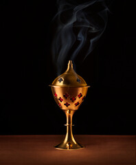 An Arabic bakhoor or Oud burner and a rosary. Islamic religious objects and background.