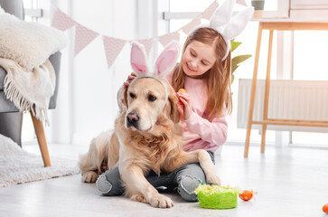 Little girl with golden retriever dog at Easter