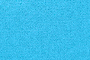 Porous blue background from a kitchen sponge. Blue background made of soft synthetic material with a chaotic close-up of pores. Free space for ads and text