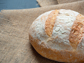 Close-up of fresh crispy round-shaped wheat bread on a dark background. Side view. The concept of baking, bakeries