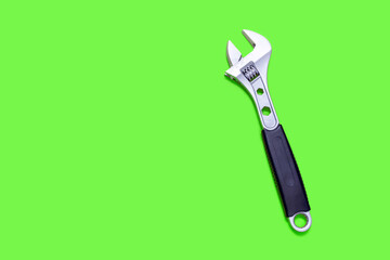 Modern adjustable wrench on a green background with free space for text. The concept of a tool for repair or construction. Special tool for repairing pipes and clamp nuts