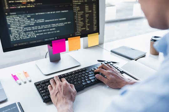 Young Professional programmer working at developing programming and website working in a software develop company office, writing codes and typing data code, Programming with HTML, PHP and javascript