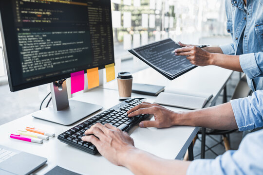 Two professional programmer cooperating and working on web site project in a software developing on desktop computer at company, codes and typing data code, Programming with HTML, PHP and javascript