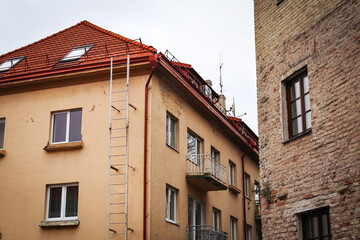 Naklejka premium Old and renovated buildings standing close to each other with white sky above roof