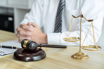 Male lawyer working with litigation contract paper documents of the estate lawsuit, Law books and wooden gavel on table office